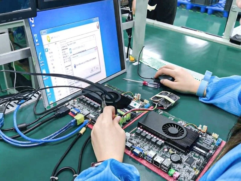 Technician performing functional testing on a PCBA with connected test interfaces