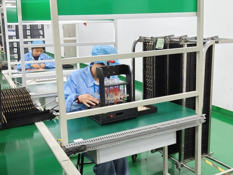 Operator using a fixture-based PCBA functional test setup in production